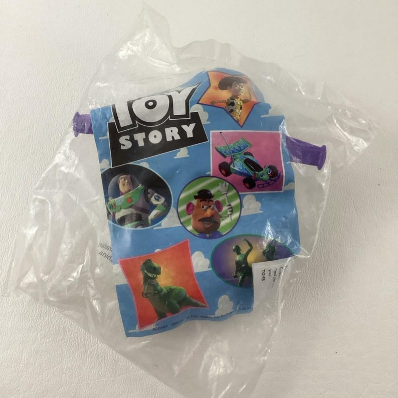May include: A sealed plastic bag featuring a "Toy Story" design. The bag has a blue background with images of characters like Buzz Lightyear, Mr. Potato Head, and Rex. The "Toy Story" logo is prominently displayed in white and black.