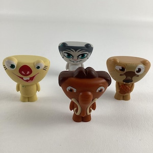 May include: Four small plastic figurines of cartoon characters. The characters are a yellow creature with a red nose, a white creature with black eyes and a black nose, a brown creature with a gray trunk, and a brown creature with a black nose and a black mouth.