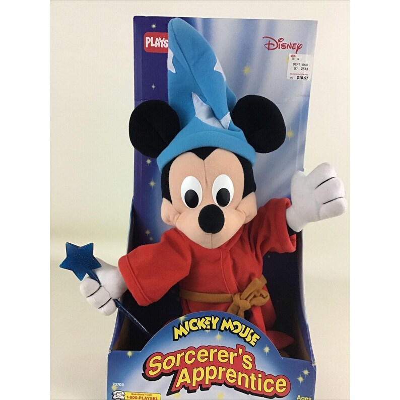 May include: A plush Mickey Mouse toy dressed as Sorcerer's Apprentice from the Disney movie Fantasia. He is wearing a blue hat, red robe, and holding a blue star wand. The packaging features the Disney logo and the words "Mickey Mouse Sorcerer's Apprentice".