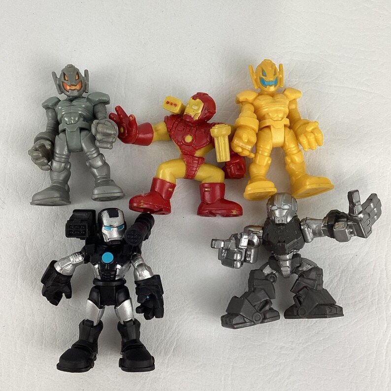 May include: A collection of five toy action figures in various colors. The figures include Iron Man, Ultron, and other characters. The toys are made of plastic and have detailed designs. The figures are posed in dynamic positions.