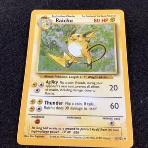 May include: A Raichu trading card from the Base Set, featuring the yellow mouse Pokémon with a lightning bolt tail. The card displays 80 HP, the Agility and Thunder attacks, and text detailing its length of 2' 7" and weight of 66 lbs.