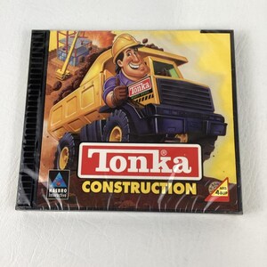 May include: A Tonka Construction CD-ROM game case featuring a yellow dump truck and a cartoon construction worker in a hard hat. The cover displays the Tonka logo, the Hasbro Interactive logo, and a red triangle indicating ages 4 and up.