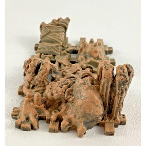 Puede incluir: Un detallado modelo de castillo en miniatura marr&oacute;n con superficies texturizadas. El modelo presenta m&uacute;ltiples torres, muros e intrincados detalles arquitect&oacute;nicos. El dise&ntilde;o general sugiere un tema de fantas&iacute;a o hist&oacute;rico.