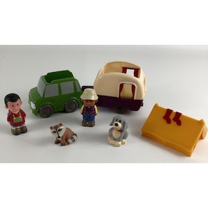 May include: A set of plastic toy figures for a camping theme. The set includes a green car, a camper, a tent, a raccoon, a dog, and two people.