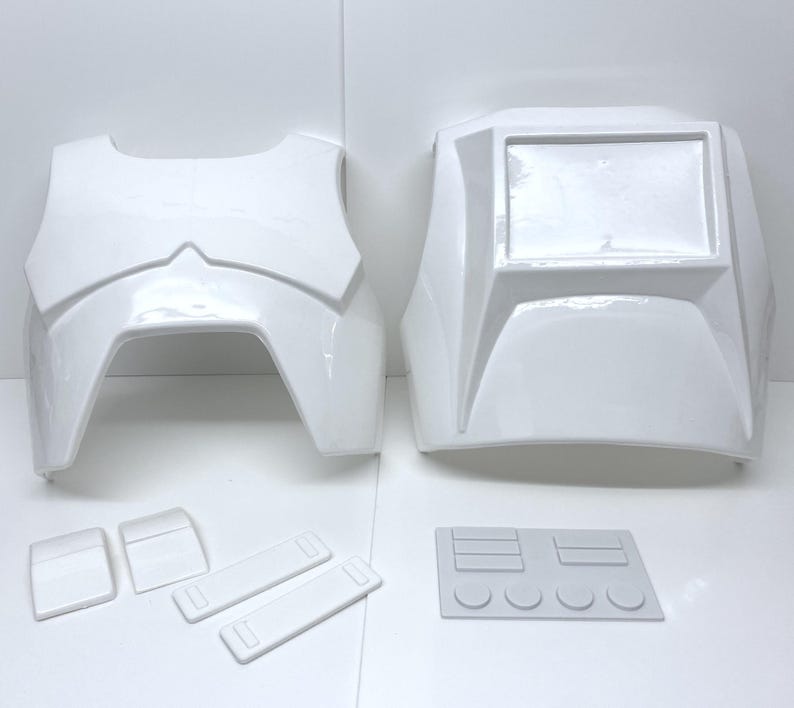 Op de afbeelding: Witte plastic pantseronderdelen, waaronder een borstplaat, rugplaat, schouderstukken en andere componenten. Het pantser heeft een glanzende afwerking en lijkt nieuw te zijn. De stukken zijn gerangschikt op een wit oppervlak, wat wijst op een cosplay- of kostuumset.