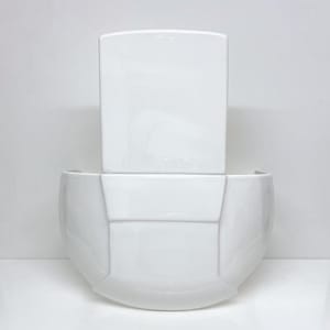 May include: White ceramic wall planter with a geometric design. The planter has a rectangular top and a rounded bottom.