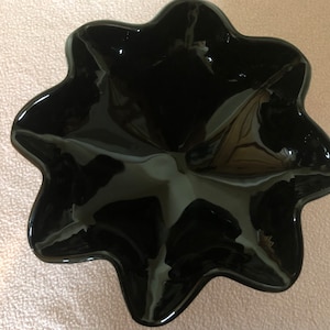 K&ouml;nnte beinhalten: Eine schwarze, sternf&ouml;rmige Keramikschale mit gl&auml;nzender Oberfl&auml;che.