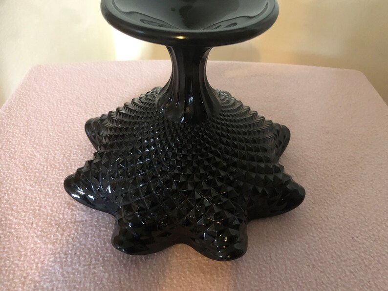 K&ouml;nnte beinhalten: Schwarzer Glassockel mit Diamantmuster. Der Sockel hat eine breite, flache Oberseite und eine ausgestellte Basis.