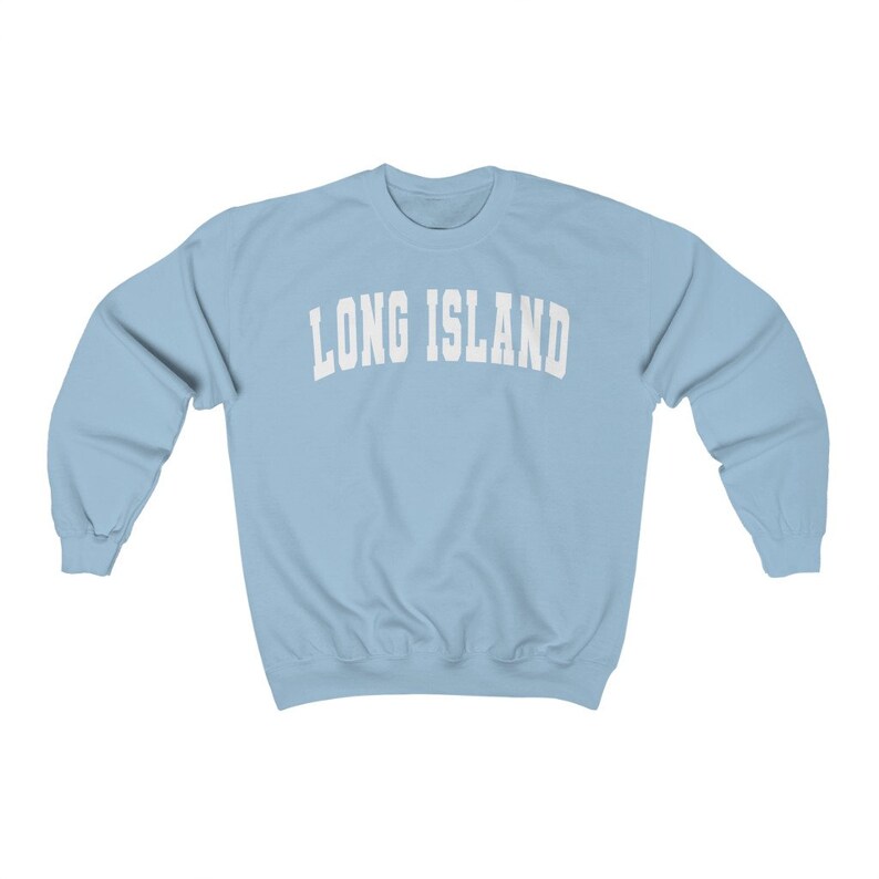 Puede incluir: Una sudadera de color azul claro con el texto "LONG ISLAND" impreso en blanco en la parte delantera.