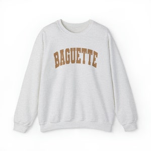 May include: A gray sweatshirt with a brown "BAGUETTE" graphic printed on the front.