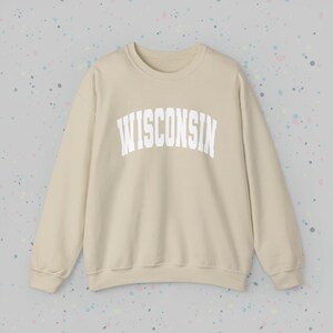 May include: A beige sweatshirt with the word "WISCONSIN" printed in white on the front.