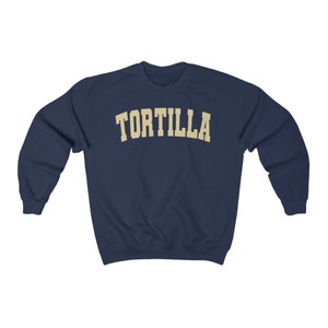 Puede incluir: Una sudadera azul marino con la palabra "TORTILLA" impresa en color crema en el pecho.