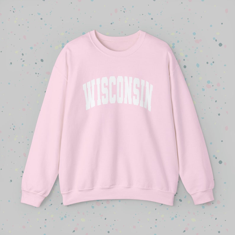 May include: A pink sweatshirt with the word "WISCONSIN" printed in white on the front.