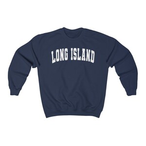 Puede incluir: Una sudadera azul marino con el texto "LONG ISLAND" en blanco, en letras arqueadas.