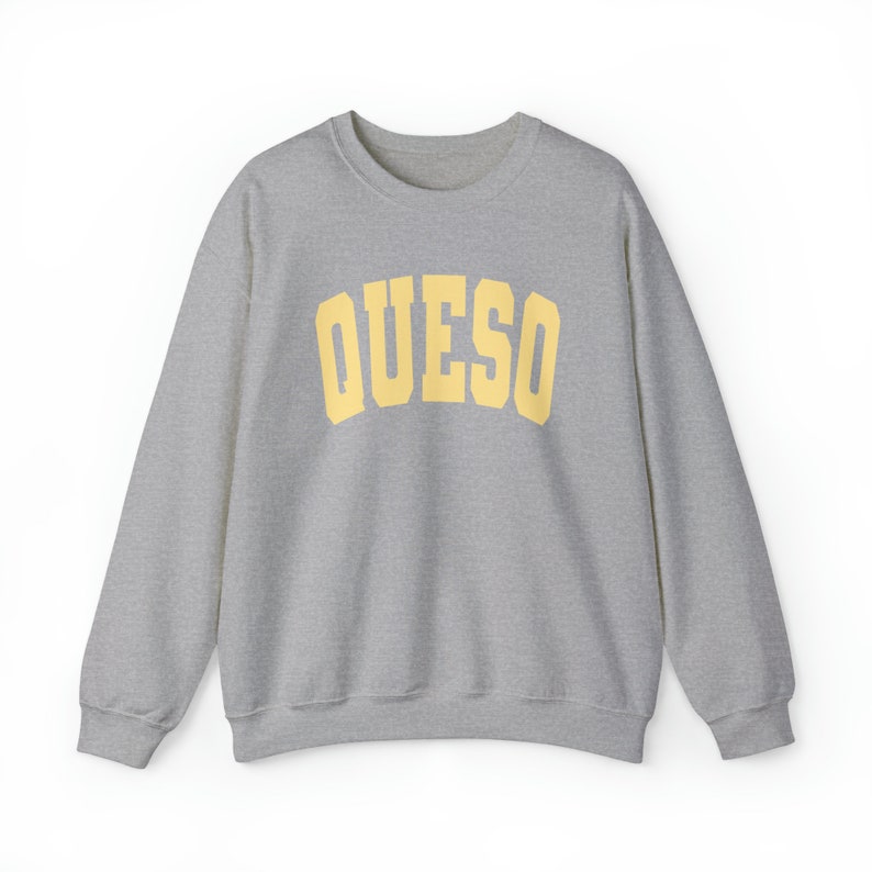 May include: A gray sweatshirt with a yellow arch design that says "QUESO" on the front.