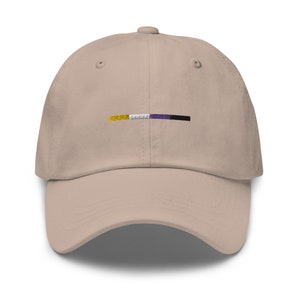 May include: A beige baseball cap with a horizontal stripe of yellow, white, purple, and black.