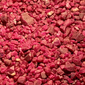 May include: A close-up view of a large pile of ruby red gemstones. The stones are various sizes and shapes, and they are all very shiny.