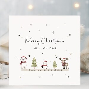 May include: A cream-coloured Christmas card with the text "Merry Christmas" and "Mrs Johnson". The card features illustrations of a polar bear, penguin, Christmas trees, and a reindeer, all wearing festive hats. The phrase "thank you for everything" is also included.