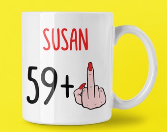 May include: White ceramic mug with the name "SUSAN" in red, the number "59+" in black, and a hand giving the middle finger with red nail polish. The mug has a white handle and is set against a yellow background.