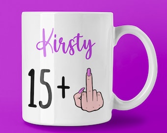 May include: White ceramic mug with the name "Kirsty" in purple script, the numbers "15+" in black, and a graphic of a hand giving the middle finger with a pink nail polish. The mug has a curved handle.