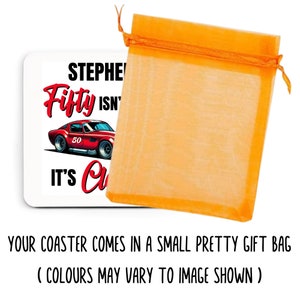 以下が含まれることがあります： 「Stephen Fifty Isn't It's Cool」の文字と赤いスポーツカーのグラフィックが描かれた白いコースター。コースターはオレンジ色のギフトバッグに入っています。