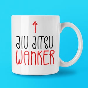 May include: A white ceramic mug featuring a red upward-pointing arrow above the black text JIU JITSU and the red text WANKER. The mug has a standard cylindrical body with a curved handle on the right side, displaying clear, bold lettering.