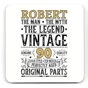 May include: White square coaster with the text "ROBERT THE MAN THE MYTH THE LEGEND VINTAGE 90 GENUINE QUALITY OLD STYLE TOP NOTCH PERFECTLY AGED ORIGINAL PARTS" in black and gold lettering.