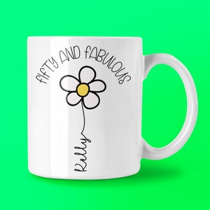 May include: White ceramic mug featuring the text "FIFTY AND FABULOUS" in black, and a daisy illustration with a yellow centre. The name "Kelly" is written in script below the flower.