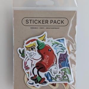Könnte beinhalten: Eine Packung bunter Cartoon-Aufkleber. Die Packung enthält einen Aufkleber einer roten Chilisoßenflasche auf einem Skateboard, einen blonden Anime-Charakter und andere lustige Designs. Die Verpackung trägt die Aufschrift "STICKER PACK" und "DURABLE VINYL WEATHERPROOF."