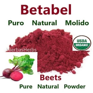 Op de afbeelding: Een close-up van een hoop rode bietpoeder. Het poeder is geëtiketteerd als "Betabel Puro Natural Molido" en "Beets Pure Natural Powder". Het USDA Organic-zegel is zichtbaar in de rechterbovenhoek van de afbeelding. Een biet met groene bladeren is te zien in de linkerbenedenhoek.