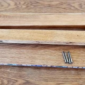 K&ouml;nnte beinhalten: Zwei Holzbretter mit einer braunen Holzbasis und vier silbernen N&auml;geln. Die Bretter sind &uuml;bereinander gestapelt und die Basis befindet sich darunter.
