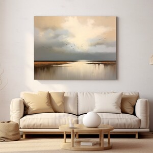 May include: A painting depicting a seascape with a golden sky and a tranquil body of water. The painting is framed and displayed on a white wall in a living room setting.