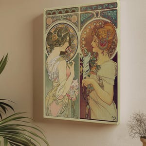 May include: Art Nouveau print showing two women in profile, set within circular frames. The women wear flowing gowns; one holds flowers, the other a feather. The colour scheme features soft greens, pinks, and golds, typical of the style.