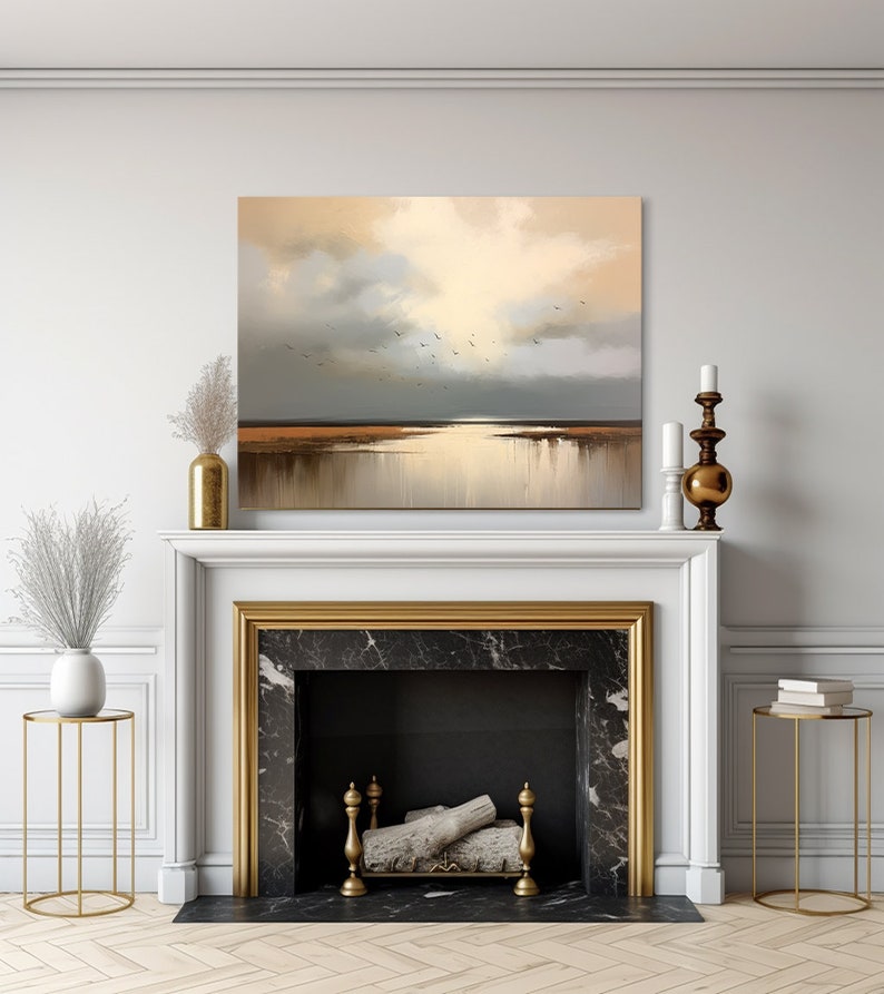 May include: A painting depicting a seascape with a golden sky and a flock of birds flying over a body of water. The painting is framed and hangs above a fireplace.