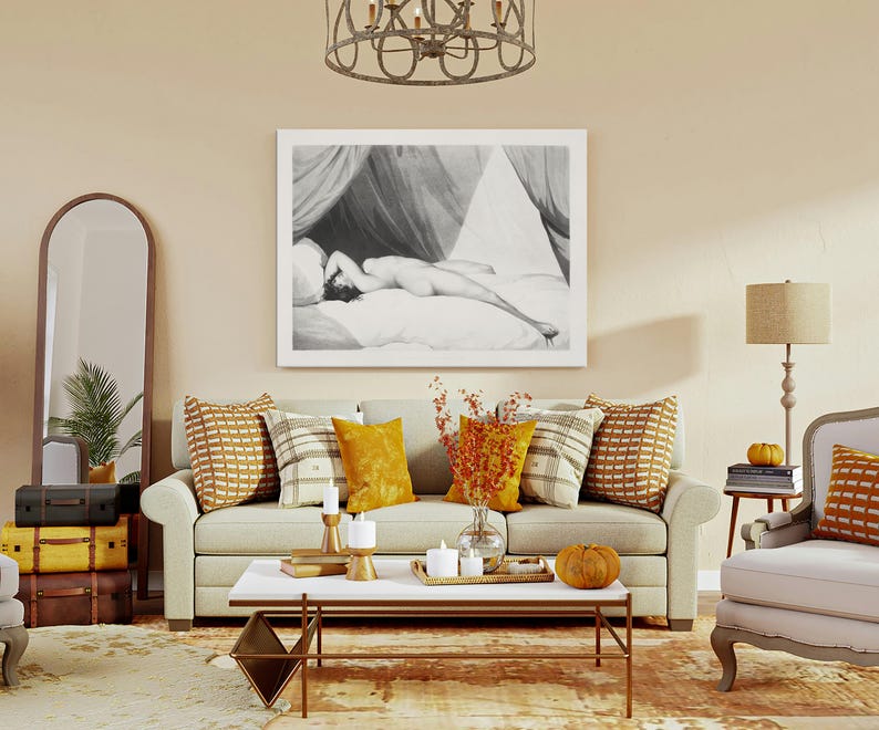 Peut inclure: Int&eacute;rieur de salon avec un canap&eacute; beige, des coussins d&eacute;coratifs et une table basse. Une grande &oelig;uvre d'art en noir et blanc encadr&eacute;e est accroch&eacute;e au-dessus du canap&eacute;. Un miroir et des valises vintage empil&eacute;es sont &agrave; gauche. Une lampe et un fauteuil sont &agrave; droite.