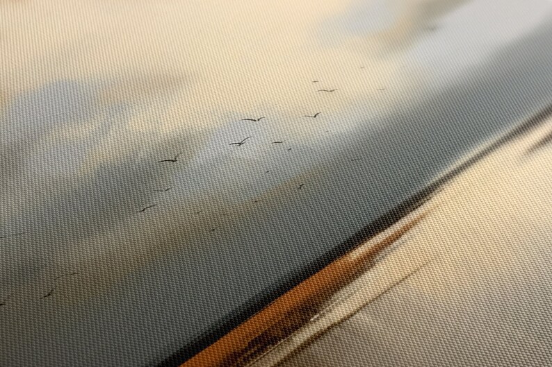 May include: A close-up of a canvas painting depicting a flock of birds flying in formation against a cloudy sky. The sky is a soft blue and white, with hints of orange and yellow. The birds are black silhouettes against the sky.