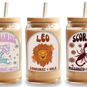 Pode incluir: Tr&ecirc;s copos de vidro com tampas e canudos de bambu, cada um com um signo do zod&iacute;aco diferente: Aqu&aacute;rio, Le&atilde;o e Escorpi&atilde;o. O copo de Aqu&aacute;rio tem um design turquesa e roxo, o copo de Le&atilde;o tem um le&atilde;o e o copo de Escorpi&atilde;o tem um escorpi&atilde;o.