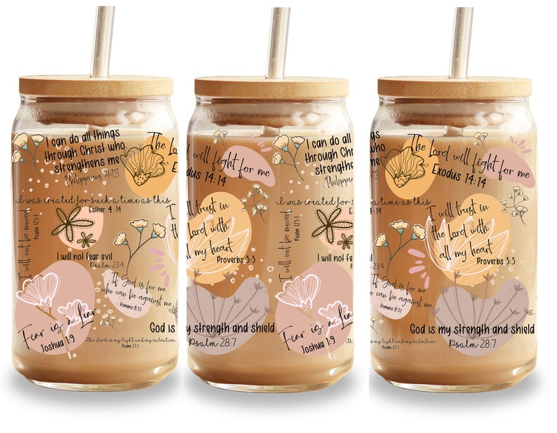 May include: Glass tumbler with a bamboo lid and straw, featuring a floral design and inspirational quotes in various fonts. The tumbler has a light brown beverage inside, with a beige and pink color palette.