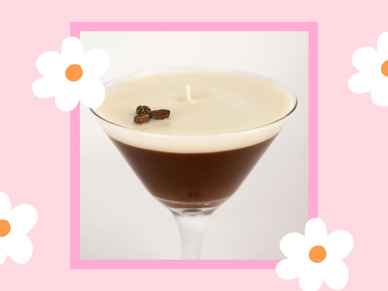 May include: A white and brown coffee-themed candle in a martini glass. The candle has a white top layer and a brown bottom layer. There are coffee beans on top of the white layer.