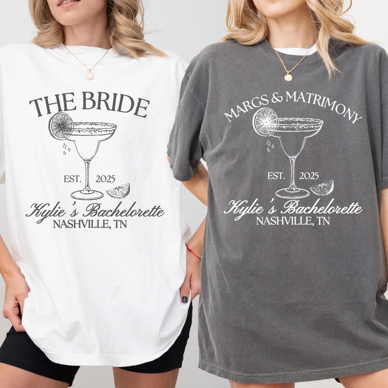 K&ouml;nnte beinhalten: Zwei kurz&auml;rmelige T-Shirts, eines in Wei&szlig; und eines in Anthrazit, mit grafischen Aufdrucken eines Margaritaglases mit Limette. Das wei&szlig;e T-Shirt tr&auml;gt die Aufschrift THE BRIDE, EST. 2025, Kylie's Bachelorette, NASHVILLE, TN.