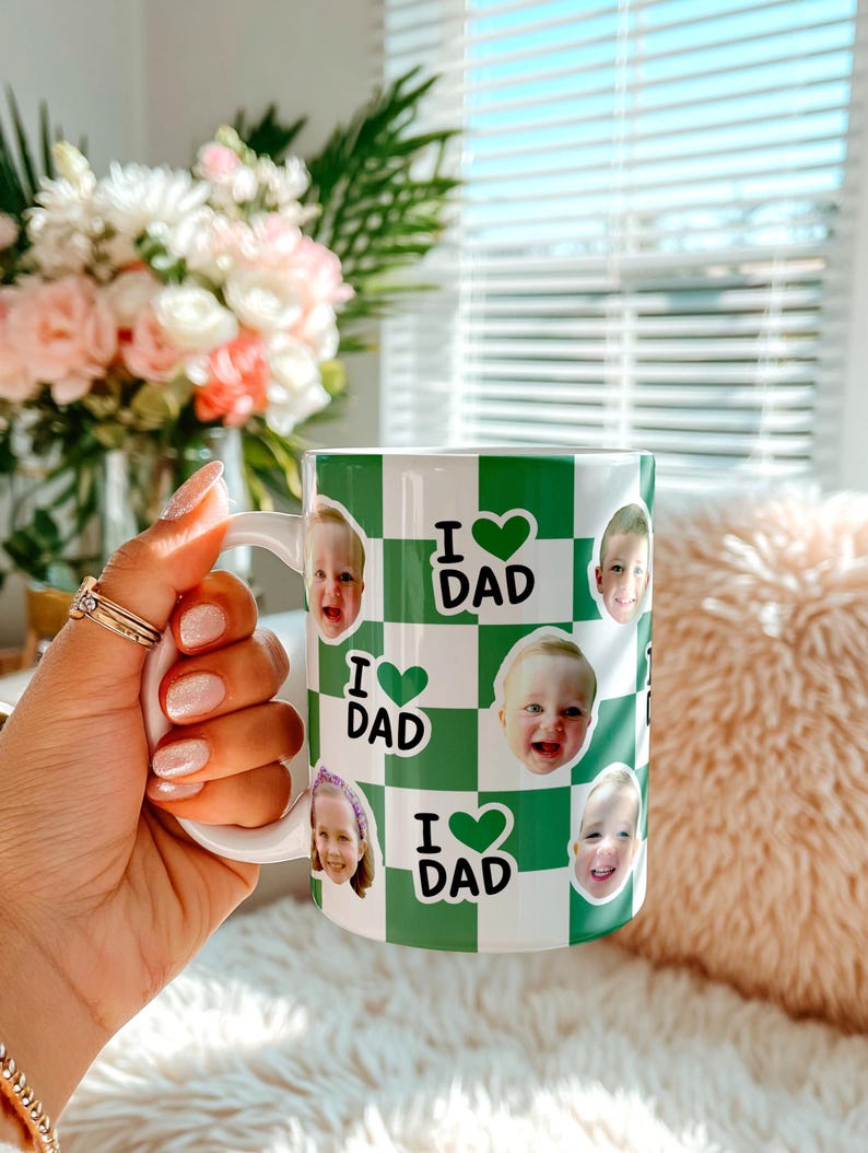 K&ouml;nnte beinhalten: Wei&szlig;e Keramiktasse mit gr&uuml;n-wei&szlig;em Karomuster. Die Tasse zeigt Fotos von Kindern und den Text "I ❤️ DAD". Die Tasse ist ein Geschenk zum Vatertag.