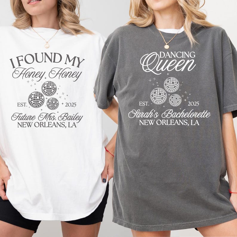 K&ouml;nnte beinhalten: Zwei T-Shirts, eines wei&szlig; und eines grau, mit Text und Discokugel-Grafiken. Das wei&szlig;e Shirt tr&auml;gt die Aufschrift "I Found My Honey Honey" und "Future Mrs. Bailey, New Orleans, LA". Das graue Shirt tr&auml;gt die Aufschrift "Dancing Queen" und "Sarah's Bachelorette, New Orleans, LA."
