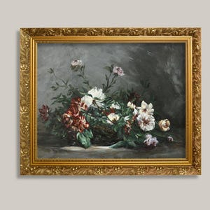 以下が含まれることがあります： 装飾的な金色のフレームに入った長方形の油絵。暗い背景を前に、暗いバスケットに生けられた白と濃い赤の花の静物画です。このアートワークには、目に見える筆致と落ち着いた色調が表現されており、全体的に重厚な雰囲気を醸し出しています。