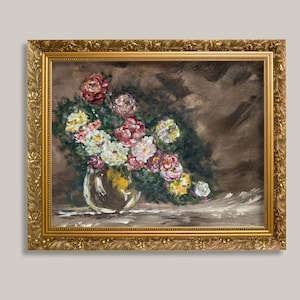 以下が含まれることがあります： 装飾的なゴールドのフレームに入った油絵で、ガラスの花瓶に生けられた花束が描かれています。赤、ピンク、白、黄色の花々が、筆致が見えるダークブラウンの背景に配置されています。