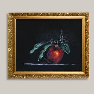 以下が含まれることがあります： 黒い背景に緑の葉がついた赤いリンゴを描いた油絵で、装飾が施された質感のある金色の額縁に入っています。作品には目に見える筆致と、リンゴの表面に明るいハイライトが表現されています。