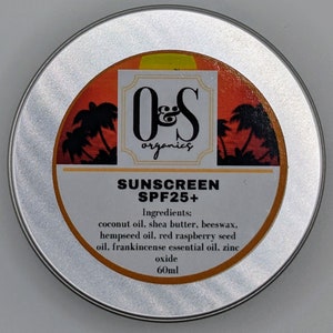 Op de afbeelding: Een ronde, zilveren blik van O&S Organics zonnebrandcrème SPF25+. Het etiket toont een zonsondergang met palmbomen en de tekst "SUNSCREEN SPF25+". Ingrediënten zijn onder meer kokosolie, sheaboter en zinkoxide. Het blik bevat 60 ml.