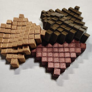 Peut inclure: Trois carreaux de mosaïque en forme de cœur faits de petits blocs carrés. Les carreaux sont dans des tons de brun, rouge et vert.