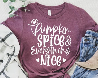 May include: A maroon t-shirt with the text "Pumpkin Spice & Everything Nice" in white lettering with small hearts on either side of the text.