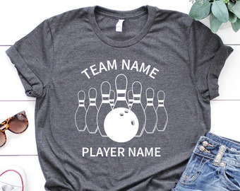 May include: A gray t-shirt with a white bowling pin graphic and the text "TEAM NAME" and "PLAYER NAME".