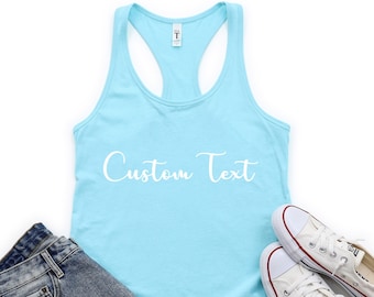 May include: A light blue racerback tank top with the text "Custom Text" printed in white on the front. The tank top is laying flat on a white surface with a pair of white sneakers and denim shorts.